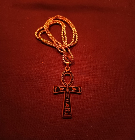 złoty krzyż ankh naszyjnik egipski amulet życia symbol ochronny czerwone tło