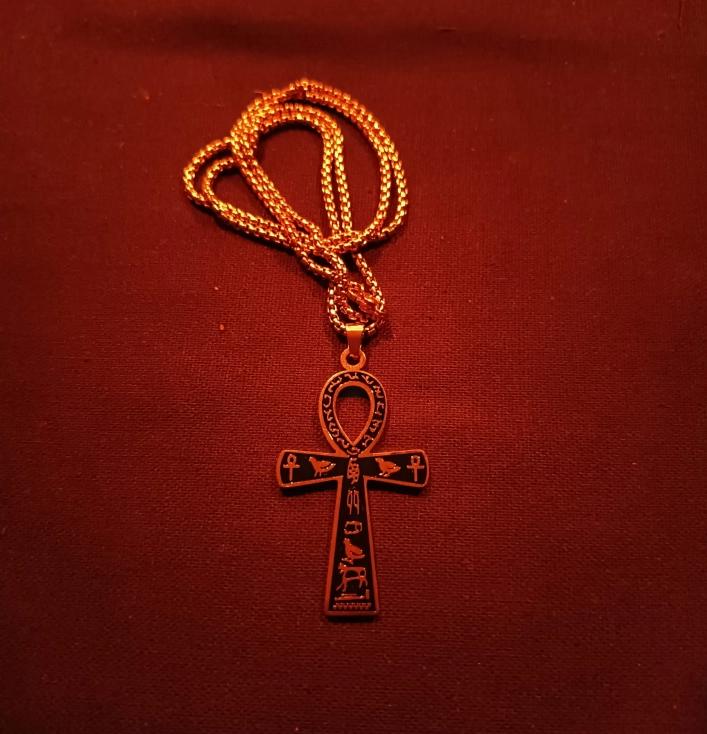 złoty krzyż ankh naszyjnik egipski amulet życia symbol ochronny czerwone tło
